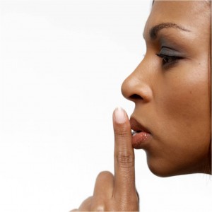 women with finger to lips for silence