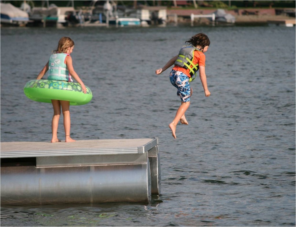 kids jumping off dock into lake